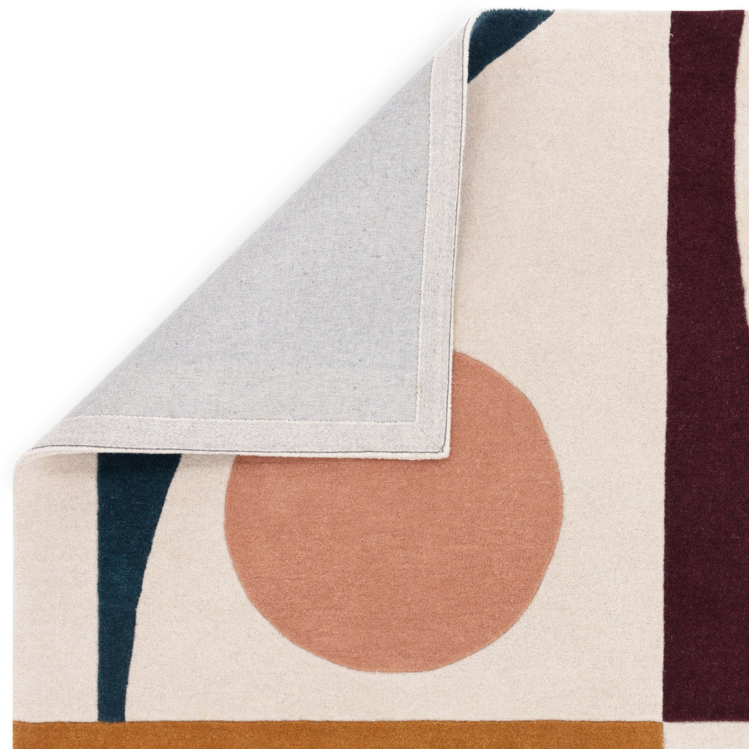 自由奔放に描かれたフォルムとアーシーカラー、アイボリー、サーモンピンク、バーガンディー、マスタードブラウン、ターコイズブルーのオリジナルな配色の組み合わせがオシャレな、天然素材ウール製RUGHAUSのハンドタフテッドのモダンアートラグの素材感と裏地がわかるクロースアップ