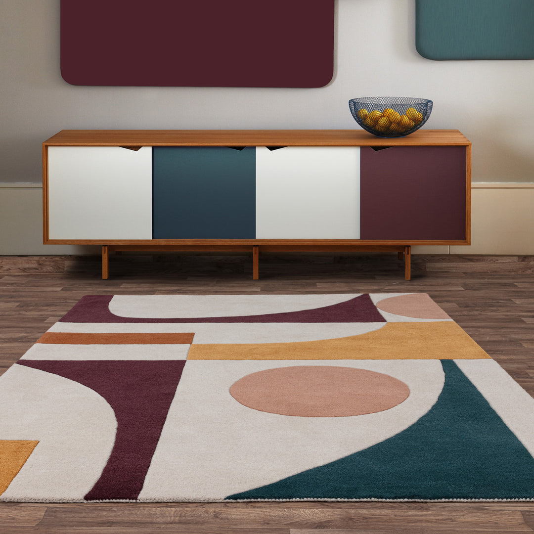 自由奔放に描かれたフォルムとアーシーカラー、アイボリー、サーモンピンク、バーガンディー、マスタードブラウン、ターコイズブルーのオリジナルな配色の組み合わせがオシャレな、天然素材ウール製RUGHAUSのハンドタフテッドのモダンアートラグを主役にした北欧モダンなリビングルーム