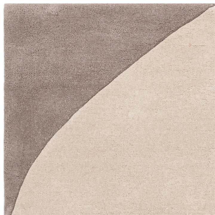 ライトグレー、アイボリー、ブラック、グレーのニュートラルカラーの自由奔放なフォルムに、まあるいバーミリオンがちょこんと映える、天然素材ウール製RUGHAUSのハンドタフテッドのモダンアートラグの素材感がわかるクロースアップ