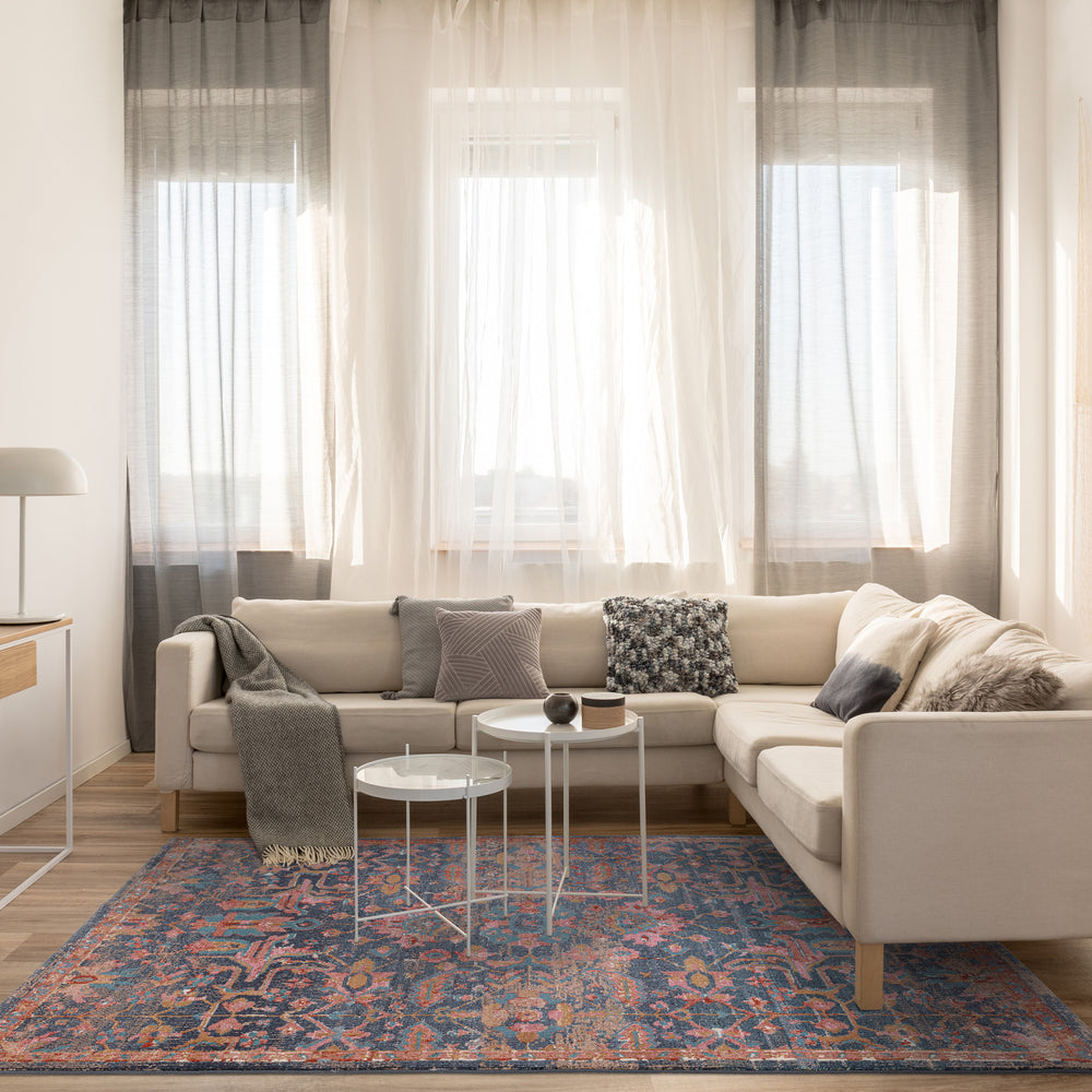 伝統的なペルシャ柄のデザインをモチーフにした緻密なクラシックパターンが可憐な、ネイビーブルー×ローズピンク色のRUGHAUSのヴィンテージスタイルオリエンタルラグを主役にしたモダンなリビングルームイメージ