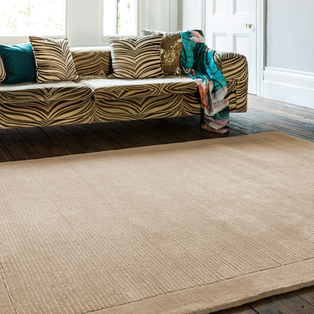 落ち着いたナチュラルなベージュカラーに、リブとボーダーがスタイリッシュ感を添える、サステナブルな天然素材ウール(羊毛)100%製RUGHAUSのふんわりシンプル手織りラグを主役にしたシックモダンなリビングルーム