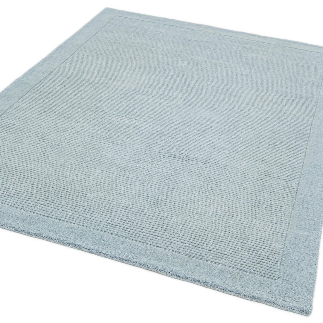 200x290cmサイズの澄み渡った空を想わせる淡いベビーブルー色に、リブとボーダーがスタイリッシュ感を添える、サステナブルな天然素材ウール(羊毛)100%製RUGHAUSのふんわりシンプル手織りラグ