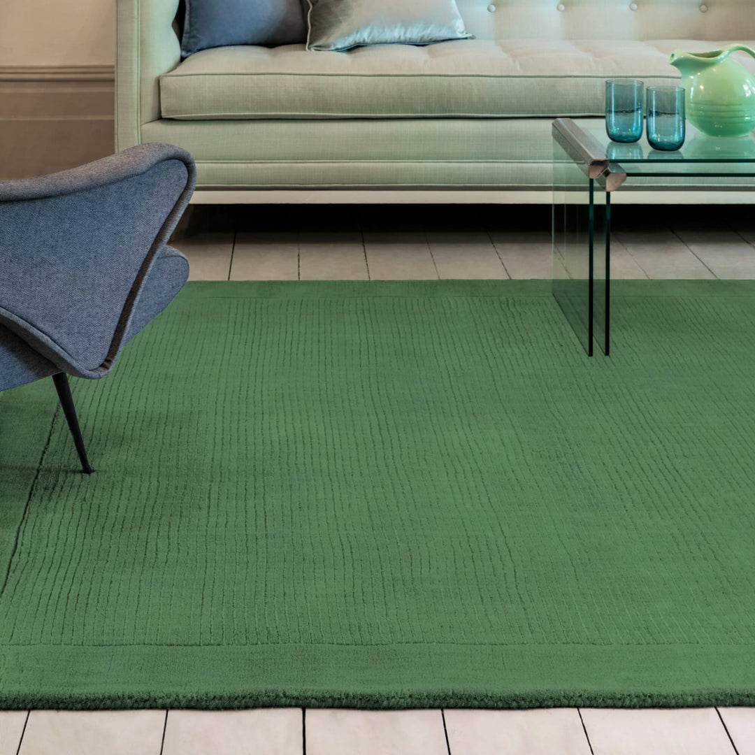 生き生きとした草葉の緑を想わせるフォレストグリーンカラーに、リブとボーダーがスタイリッシュ感を添える、サステナブルな天然素材ウール(羊毛)100%製RUGHAUSのふんわりシンプル手織りラグを主役にした彩り豊かでモダンなリビングルーム