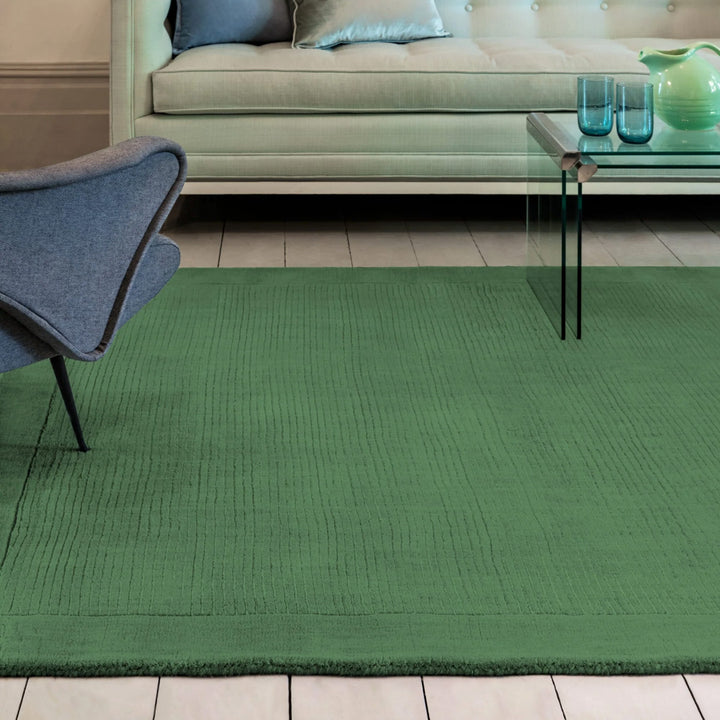 生き生きとした草葉の緑を想わせるフォレストグリーンカラーに、リブとボーダーがスタイリッシュ感を添える、サステナブルな天然素材ウール(羊毛)100%製RUGHAUSのふんわりシンプル手織りラグを主役にした彩り豊かでモダンなリビングルーム