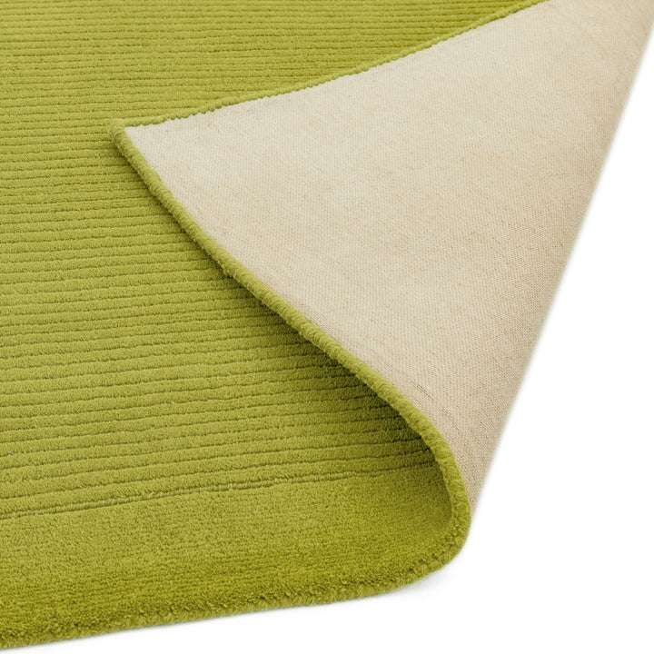 自然の息吹を想わせる爽やかなスプリンググリーンカラーに、リブとボーダーがスタイリッシュ感を添える、サステナブルな天然素材ウール(羊毛)100%製RUGHAUSのふんわりシンプル手織りラグの素材感と裏地がわかるクロースアップ