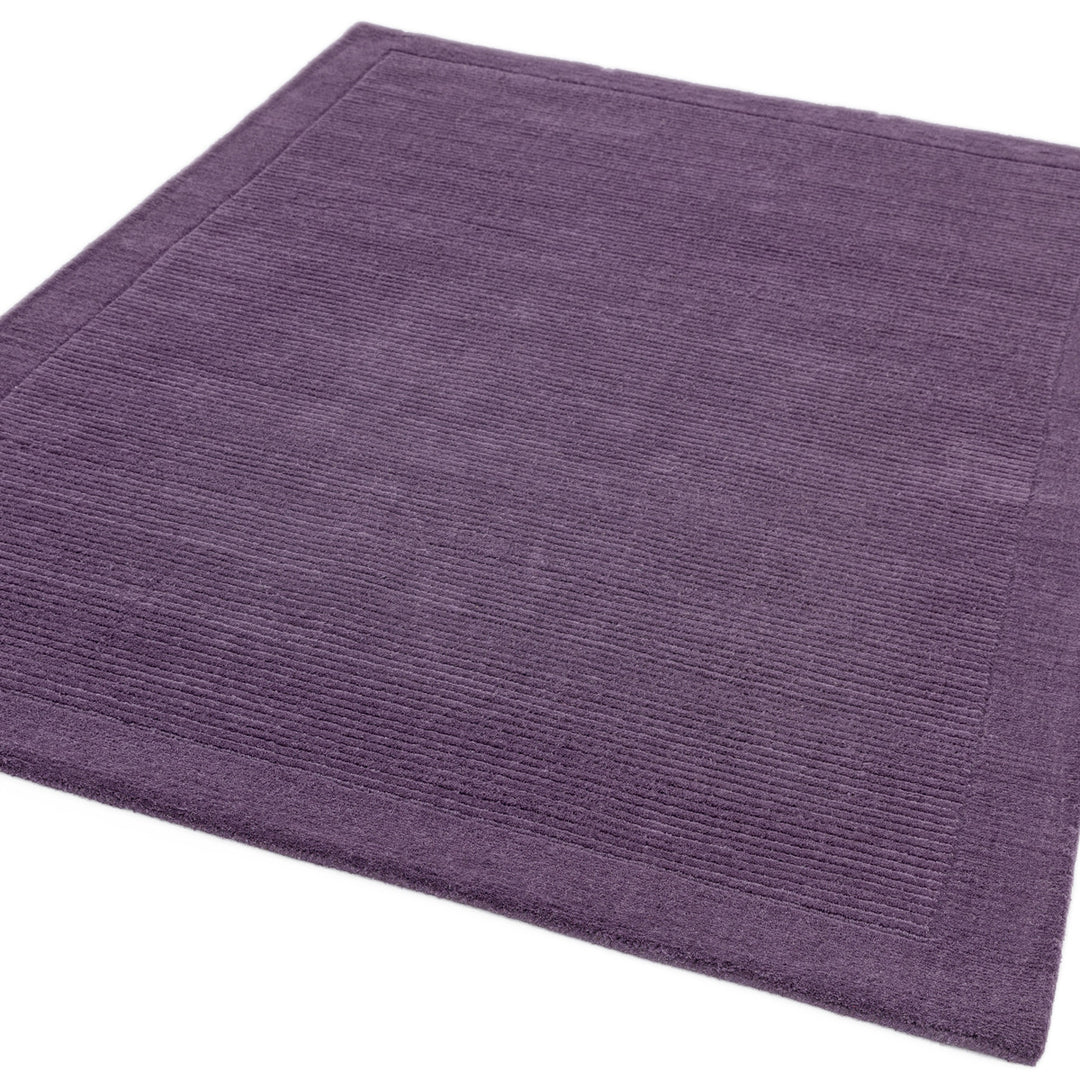 200x290cmサイズの高貴な印象が漂うパープルカラー(深みのある花紫色)に、リブとボーダーがスタイリッシュ感を添える、サステナブルな天然素材ウール(羊毛)100%製RUGHAUSのふんわりシンプル手織りラグ