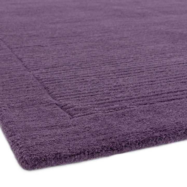 高貴な印象が漂うパープルカラー(深みのある花紫色)に、リブとボーダーがスタイリッシュ感を添える、サステナブルな天然素材ウール(羊毛)100%製RUGHAUSのふんわりシンプル手織りラグの素材感がわかるクロースアップ