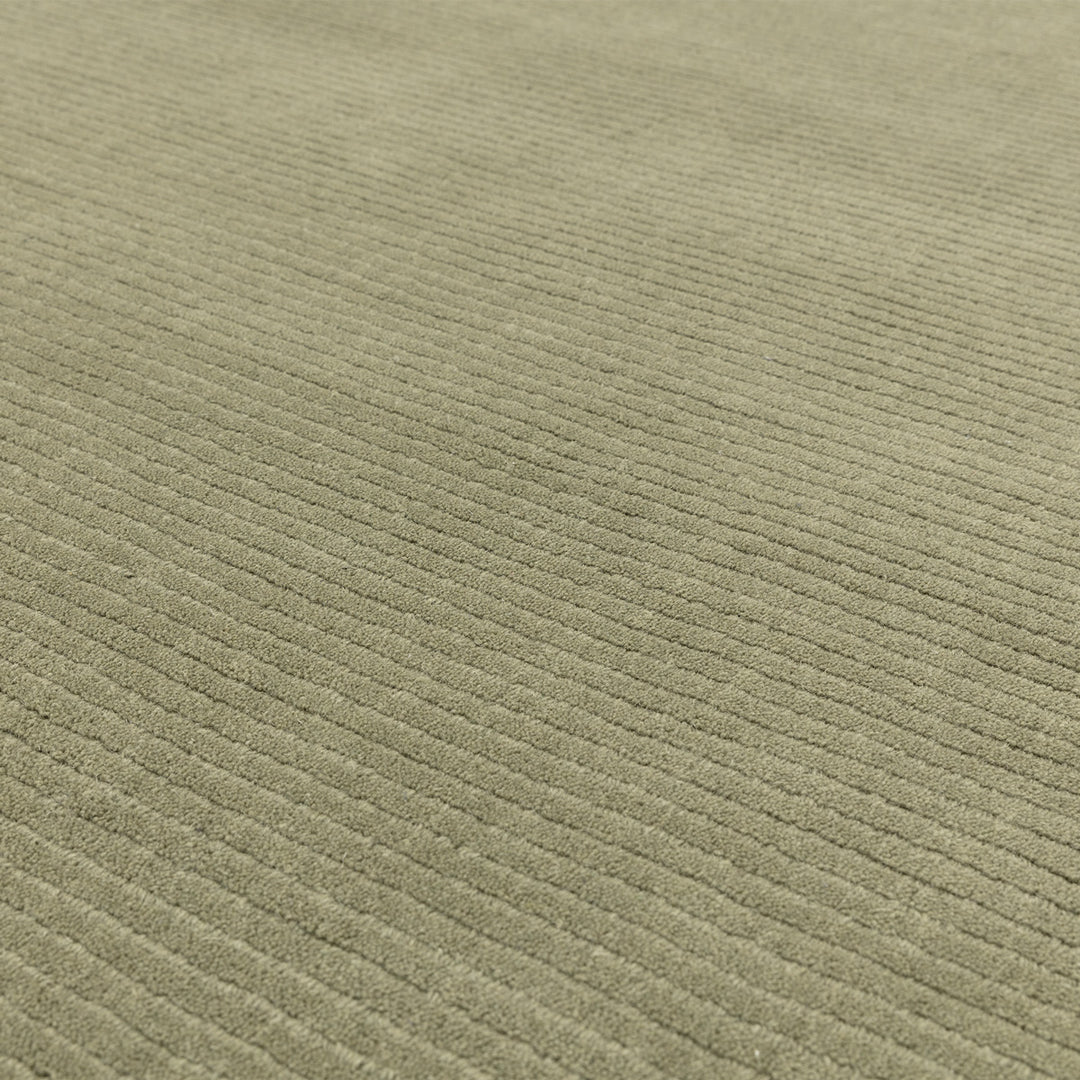 アンニュイで落ち着いたニュアンスあるセージグリーン色に、リブとボーダーがスタイリッシュ感を添える、サステナブルな天然素材ウール(羊毛)100%製RUGHAUSのふんわりシンプル手織りラグの素材感がわかるクロースアップ