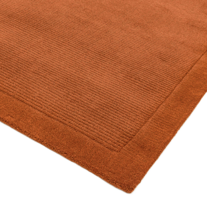 明るく温かな印象の暖色が心地よいアーシーカラー、テラコッタ(赤茶色)色の、サステナブルな天然素材ウール(羊毛)100%製RUGHAUSのふんわりシンプル手織りラグの素材感がわかるクロースアップ