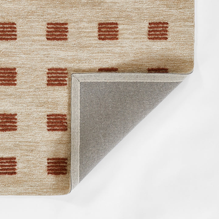 愛らしいブリック色のラストカラーがオシャレでキュートな、シンプルだけど、ほっこりする、RUGHAUSの天然素材ウール100％製ハンドタフテッドラグの素材感と裏地がわかるクロースアップ
