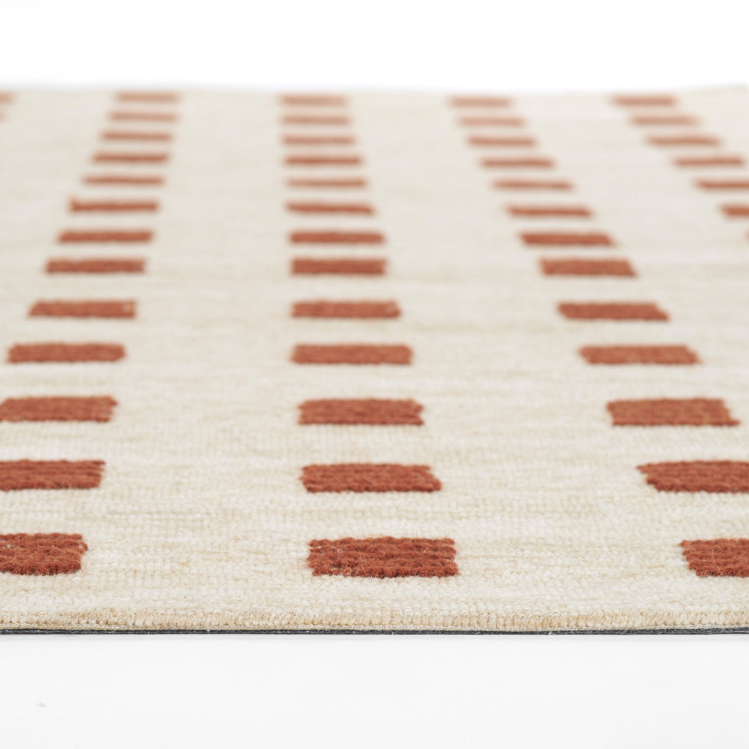 愛らしいブリック色のラストカラーがオシャレでキュートな、シンプルだけど、ほっこりする、RUGHAUSの天然素材ウール100％製ハンドタフテッドラグの素材感がわかるクロースアップ