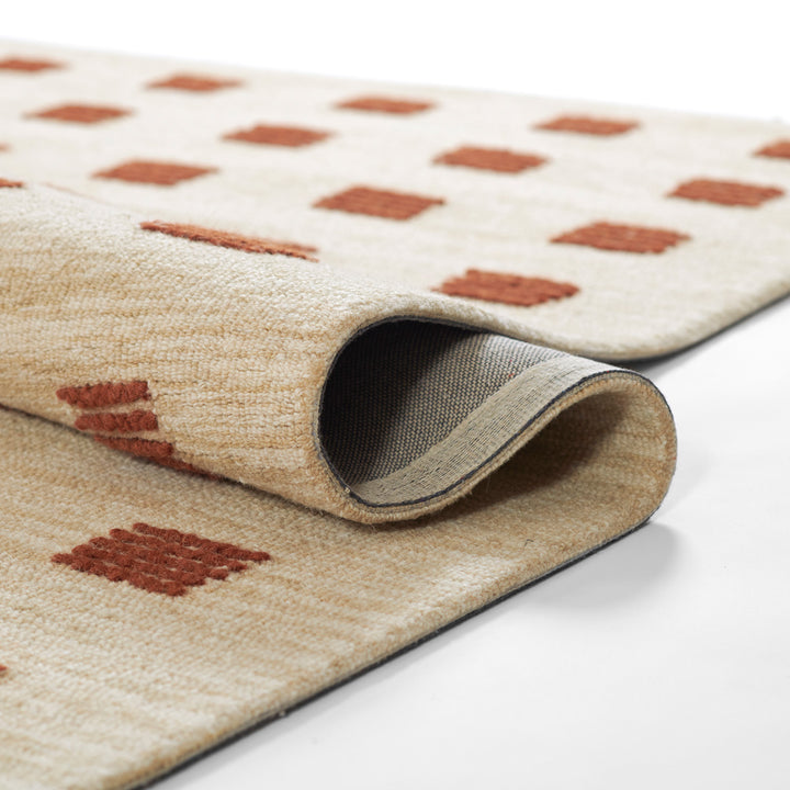 愛らしいブリック色のラストカラーがオシャレでキュートな、シンプルだけど、ほっこりする、RUGHAUSの天然素材ウール100％製ハンドタフテッドラグの素材感がわかるクロースアップ
