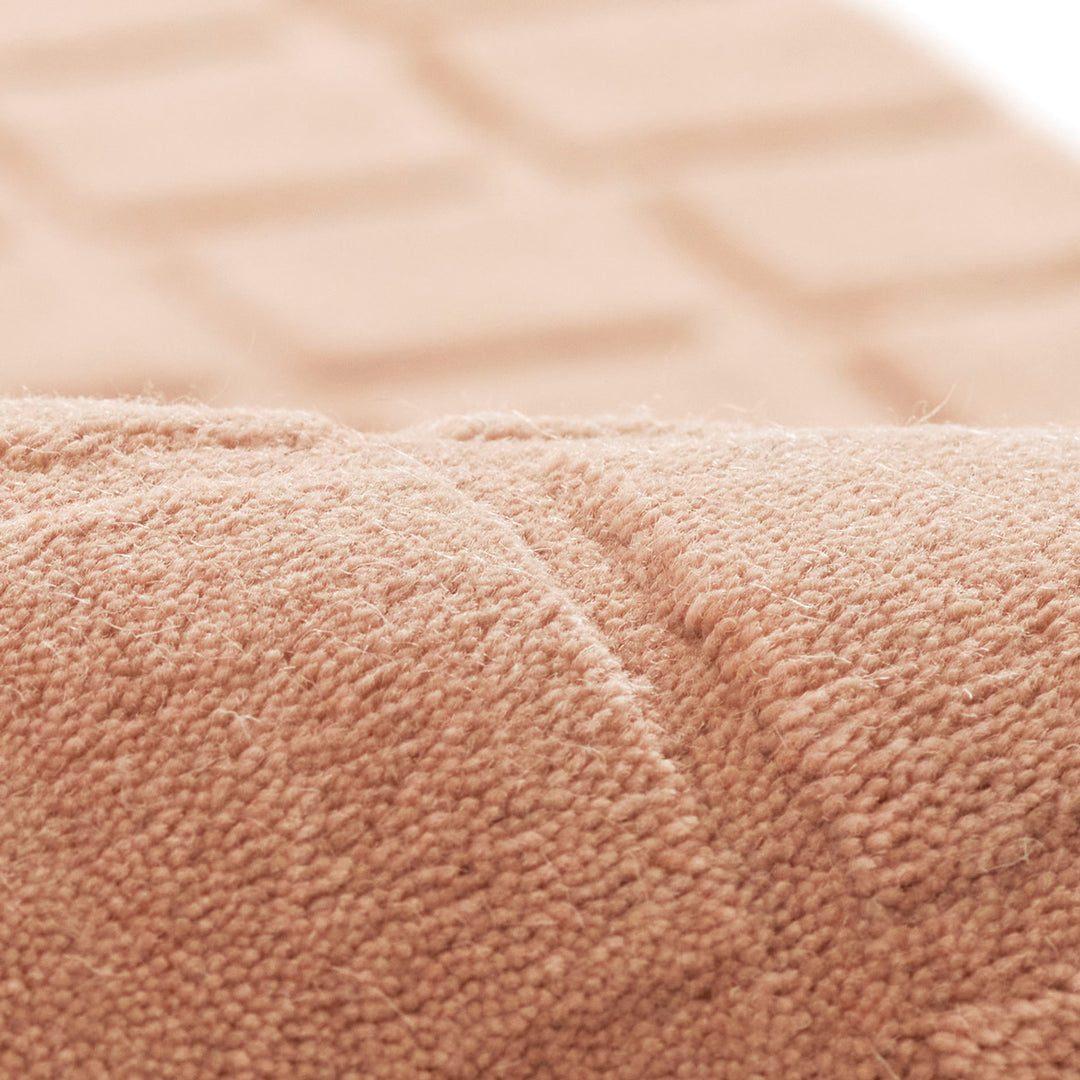 くすんだコーラルピンクのような、ニュアンスのあるアッシュローズカラー色とタイル模様が素敵な、RUGHAUSの天然素材ウール100％製手織りのエレガントモダンラグの素材感がわかるクロースアップ