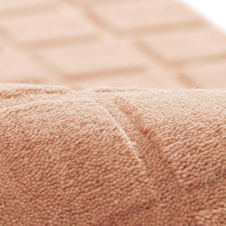 くすんだコーラルピンクのような、ニュアンスのあるアッシュローズカラー色とタイル模様が素敵な、RUGHAUSの天然素材ウール100％製手織りのエレガントモダンラグの素材感がわかるクロースアップ