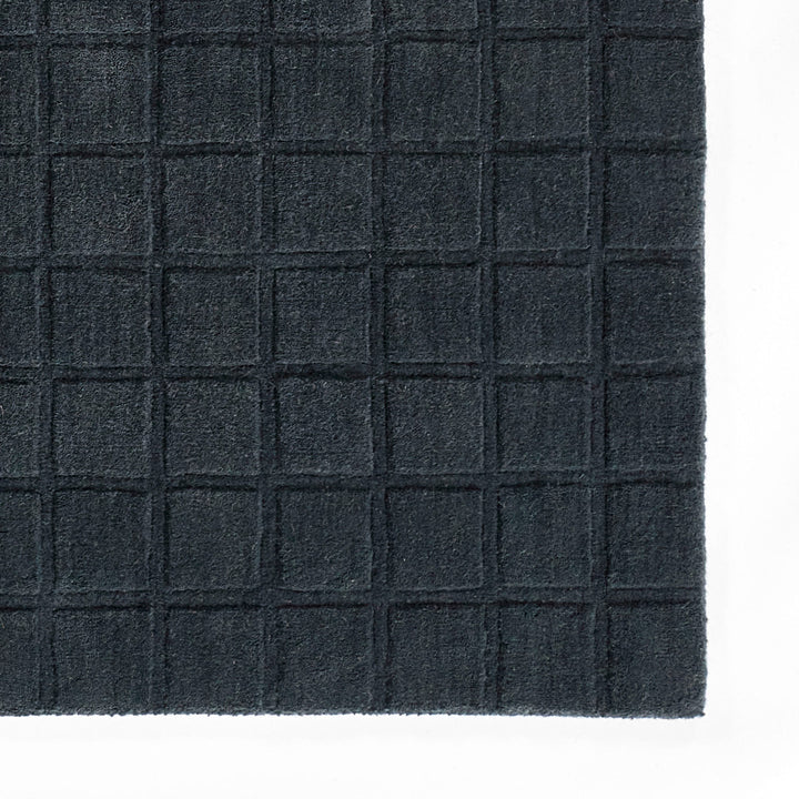 ミッドナイトブルーのように深く落ち着いた色合いのネイビーカラーとタイル模様が素敵な、RUGHAUSの天然素材ウール100％製手織りのエレガントモダンラグの素材感がわかるクロースアップ