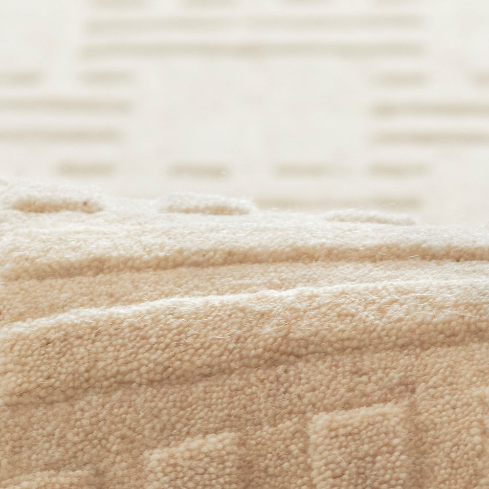 やさしいアイボリー・オフホワイト色 × 網代模様がチャーミングで立体的に織られたジオメトリックなパターンがキラリと光る、RUGHAUSの天然素材ウール製手織りのシンプルラグの素材感がわかるクロースアップ