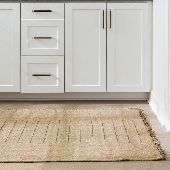 75x245cmサイズのベージュ色とゆるりとしたオシャレ感を醸し出すモカブラウンのラインがチャームポイントの、自然素材のもつ温かみをフィーチャーした、RUGHAUSの天然素材ウール×コットン製手織りのナチュラルランナーラグを主役にしたモダンなバスルームのイメージ