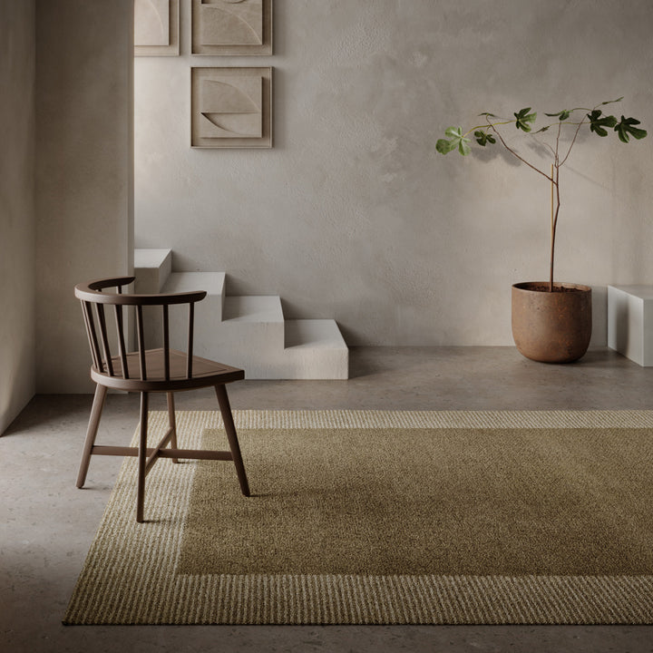 ベージュ、トープ、ブラウンベージュのアーシーなカラーパレットが大胆なボーダーの構図でキリリとハーモニーを奏でる、RUGHAUSの天然素材ウール製ハンドタフト・手織りの上質ナチュラルラグを主役にしたナチュラルモダンなリビングルーム