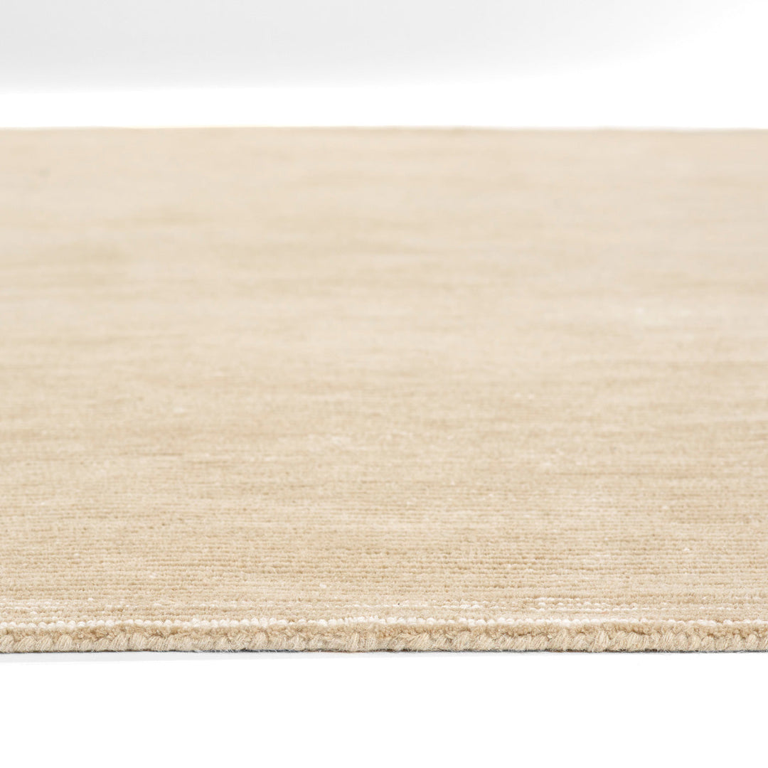 温かな印象のベージュ、オートミール、トープのカラーパレットに、幅細のリブがスタイリッシュに映えた、RUGHAUSの天然素材ウール製ハンドタフト・手織りの上質ナチュラルラグの素材感がわかるクロースアップ