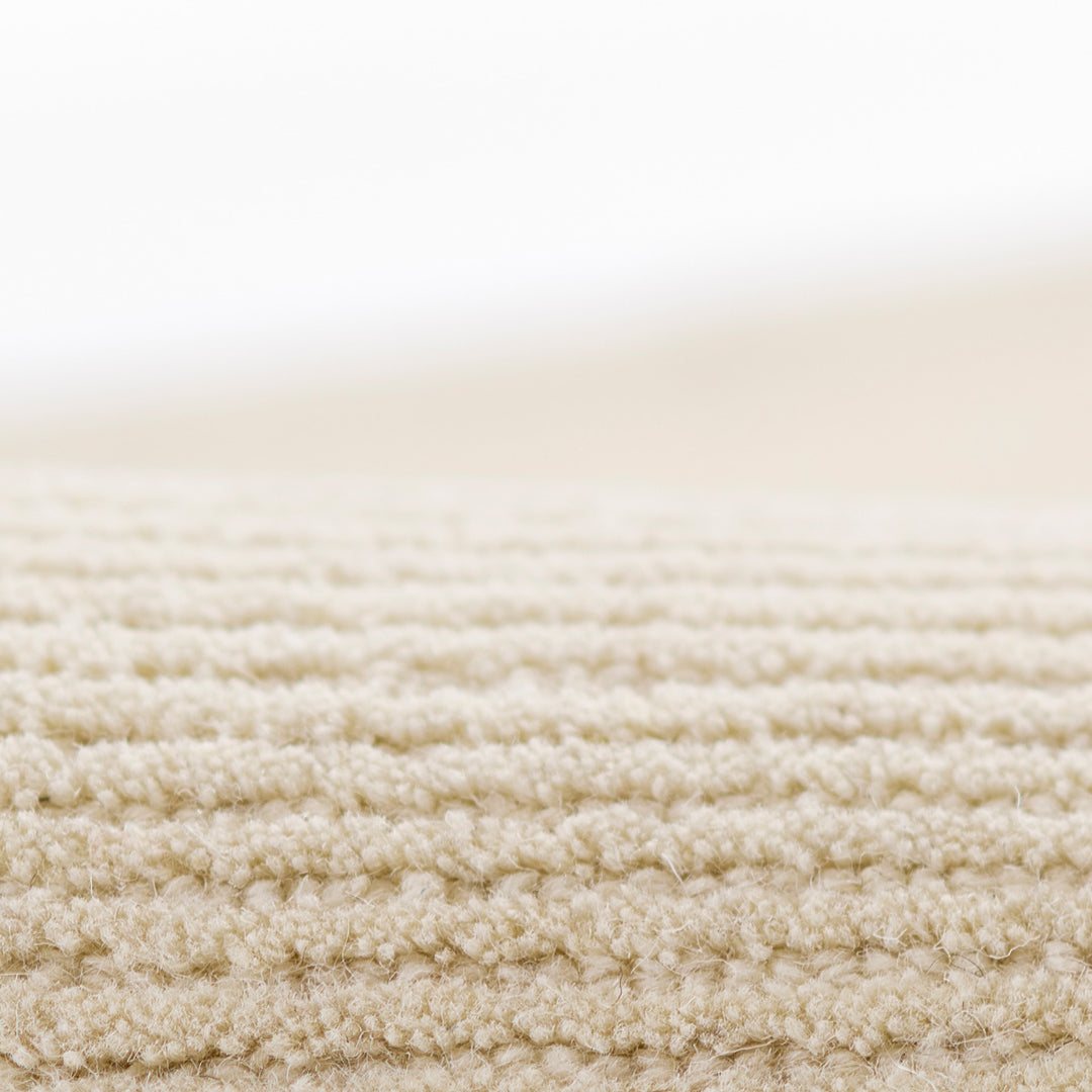 アイボリー × オートミールのニュートラルなトーンに幅細のリブがスタイリッシュに映える、シンプルで使いやすい、RUGHAUSの天然素材ウール100％製ナチュラルモダンハンドタフテッドラグの素材感がわかるクロースアップ