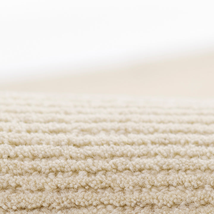 アイボリー × オートミールのニュートラルなトーンに幅細のリブがスタイリッシュに映える、シンプルで使いやすい、RUGHAUSの天然素材ウール100％製ナチュラルモダンハンドタフテッドラグの素材感がわかるクロースアップ