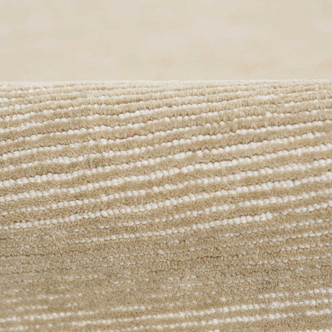 温かな印象のベージュ、オートミール、トープのカラーパレットに、幅細のリブがスタイリッシュに映えた、RUGHAUSの天然素材ウール製ハンドタフト・手織りの上質ナチュラルラグの素材感がわかるクロースアップ