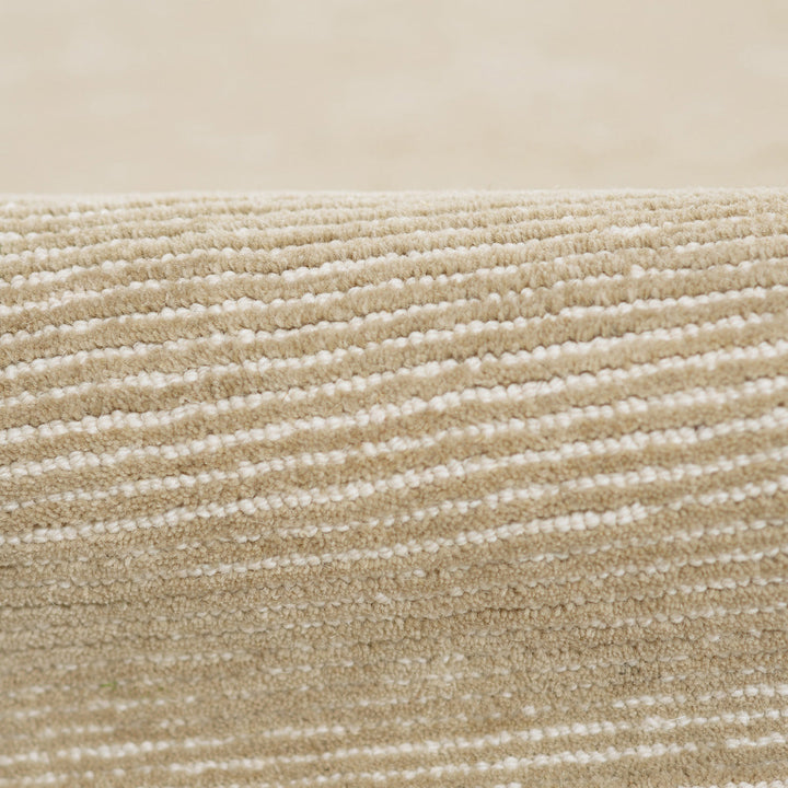 温かな印象のベージュ、オートミール、トープのカラーパレットに、幅細のリブがスタイリッシュに映えた、RUGHAUSの天然素材ウール製ハンドタフト・手織りの上質ナチュラルラグの素材感がわかるクロースアップ