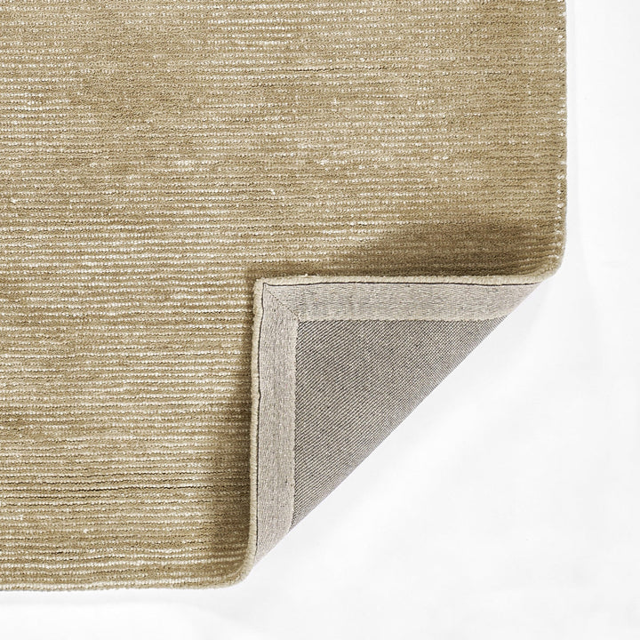 温かな印象のベージュ、オートミール、トープのカラーパレットに、幅細のリブがスタイリッシュに映えた、RUGHAUSの天然素材ウール製ハンドタフト・手織りの上質ナチュラルラグの素材感と裏地がわかるクロースアップ