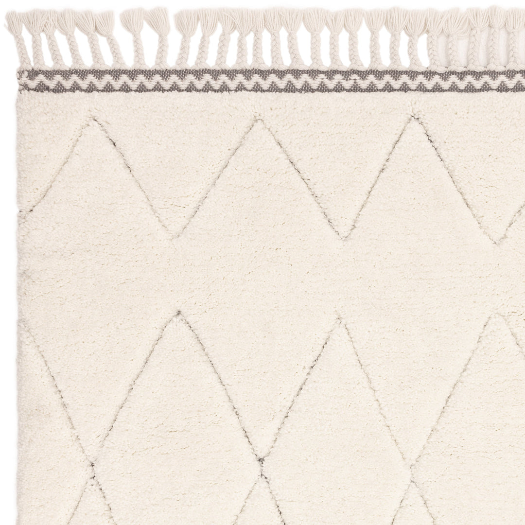 伝統的なベルベルキリムのテクスチャーやデザインにインスパイアされて織り上げた、ダイヤ模様がチャーミングな、ふわふわとした柔らかなマイクロファイバーポリエステル製RUGHAUSのベージュ・アイボリー色のベニワレンスタイルモロッカンシャギーラグの素材感がわかるクロースアップ