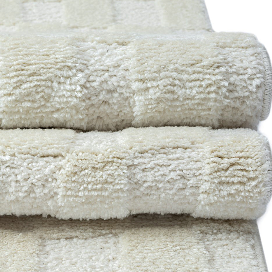 パイルの長短だけで立体的にチェック柄を表現した、アイボリーのチェッカーパターンがさりげなくチャーミングな、RUGHAUSのふんわりベーシックラグ Ninolの素材感がわかるクロースアップ