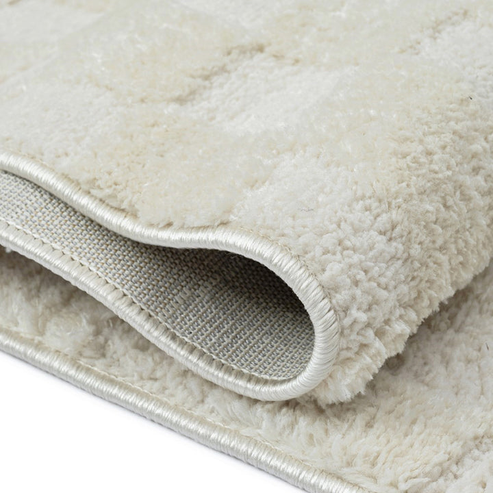 パイルの長短だけで立体的にチェック柄を表現した、アイボリーのチェッカーパターンがさりげなくチャーミングな、RUGHAUSのふんわりベーシックラグ Ninolの素材感がわかるクロースアップ