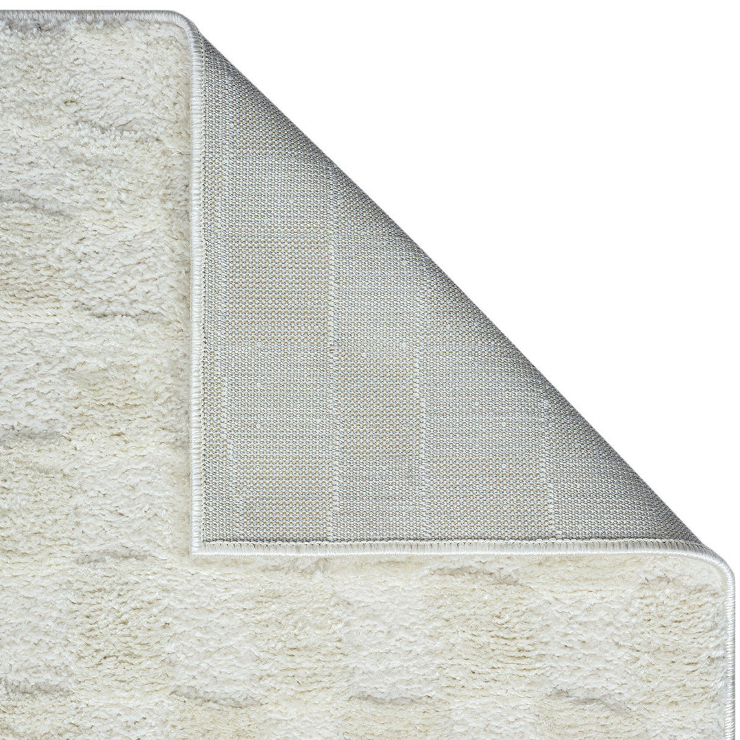 パイルの長短だけで立体的にチェック柄を表現した、アイボリーのチェッカーパターンがさりげなくチャーミングな、RUGHAUSのふんわりベーシックラグ Ninoの素材感と裏地がわかるクロースアップ