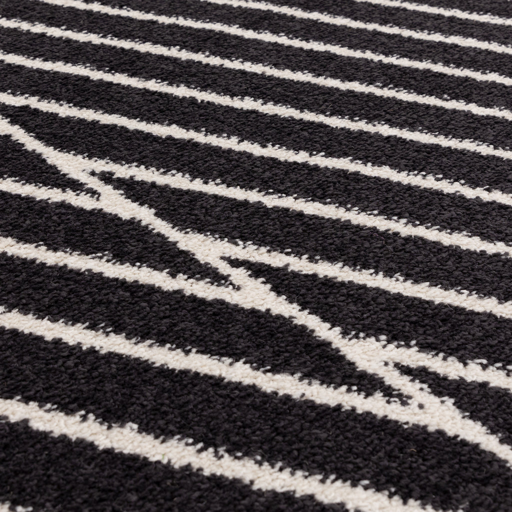 交錯した直線とモノクロのコントラストがスタイリッシュなRUGHAUSの幾何学的パターンアートランナーラグの素材感がわかるクロースアップ