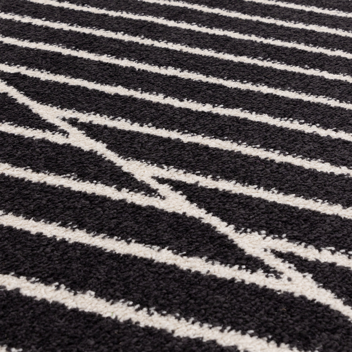 交錯した直線とモノクロのコントラストがスタイリッシュなRUGHAUSの幾何学的パターンアートランナーラグの素材感がわかるクロースアップ