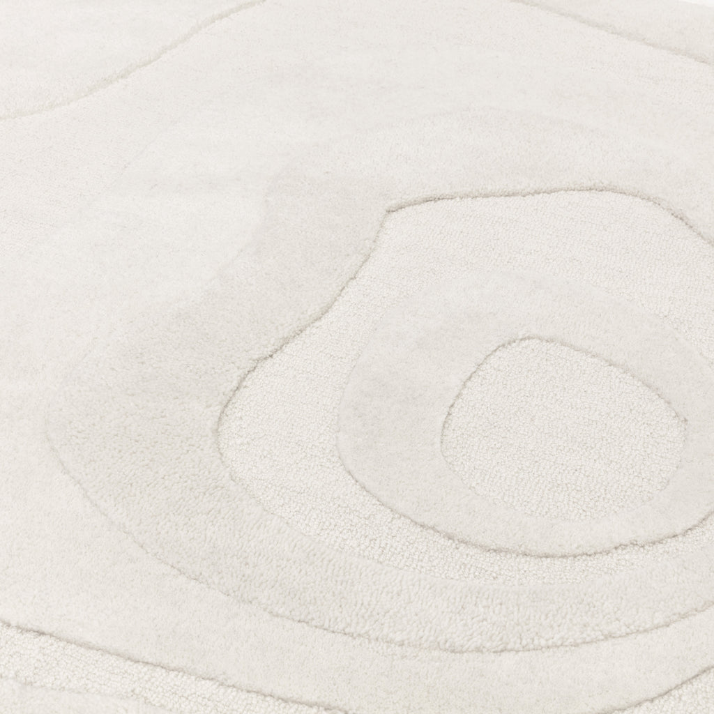ループパイルとカットパイルを組み合わせることで、繊細なデザインパターンを表現したコンテンポラリーアートのような、RUGHAUSのニュージーランド産ウール100％ハンドタフトのホワイトカラーのラウンド円形ラグの素材感がわかるクロースアップ