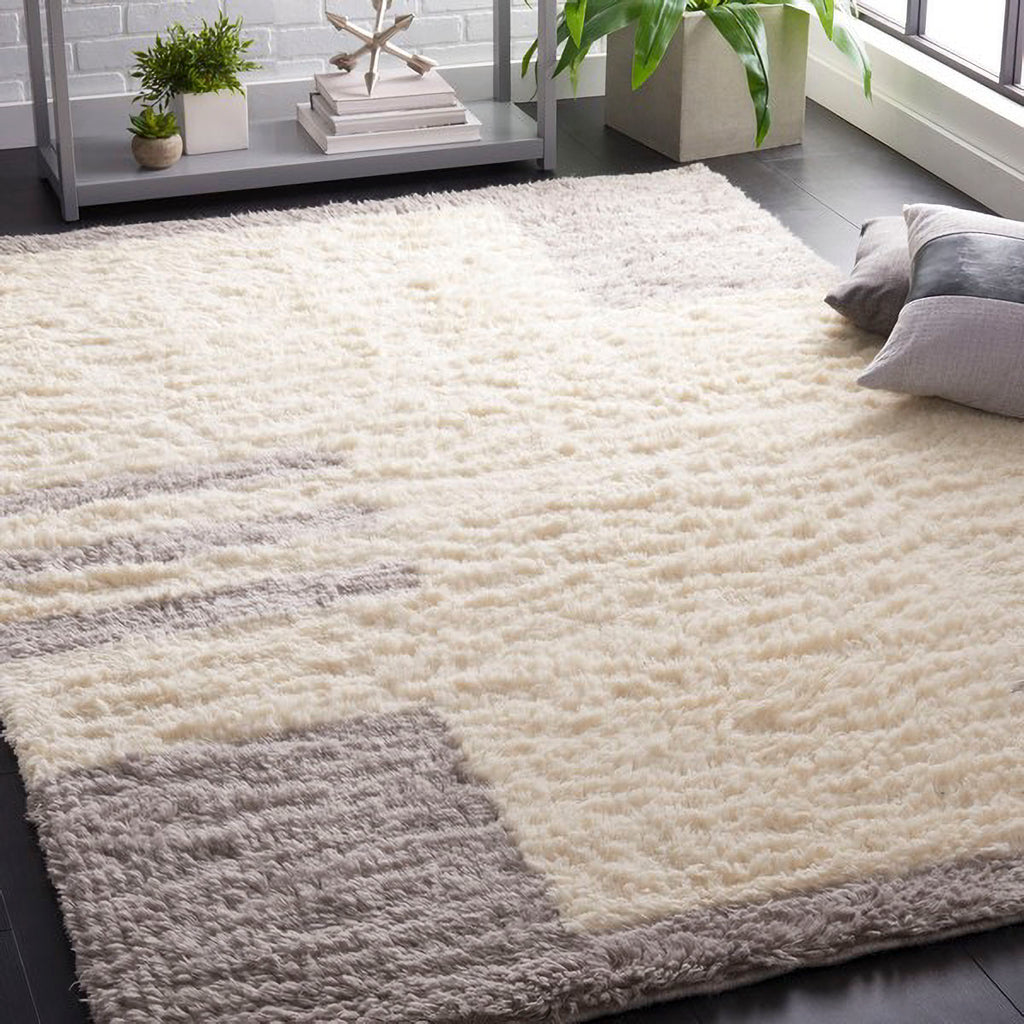 ふわふわとした手触りのアイボリー地にライトグレーのモダンなデザインが描かれたウール＆コットン製のハンドメイドアートラグを主役にしたリビングコーディネート