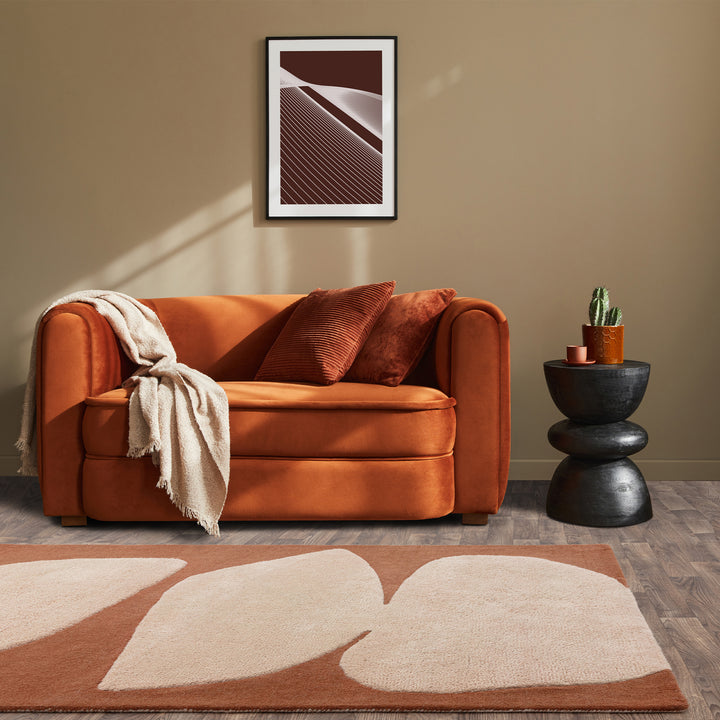 アーシーカラーのブラウンといびつなフォルムがおおらかな印象を与える、天然素材のウール100％RUGHAUSのハンドタフトアートラグを主役にしたミニマルアートなリビングルームイメージ