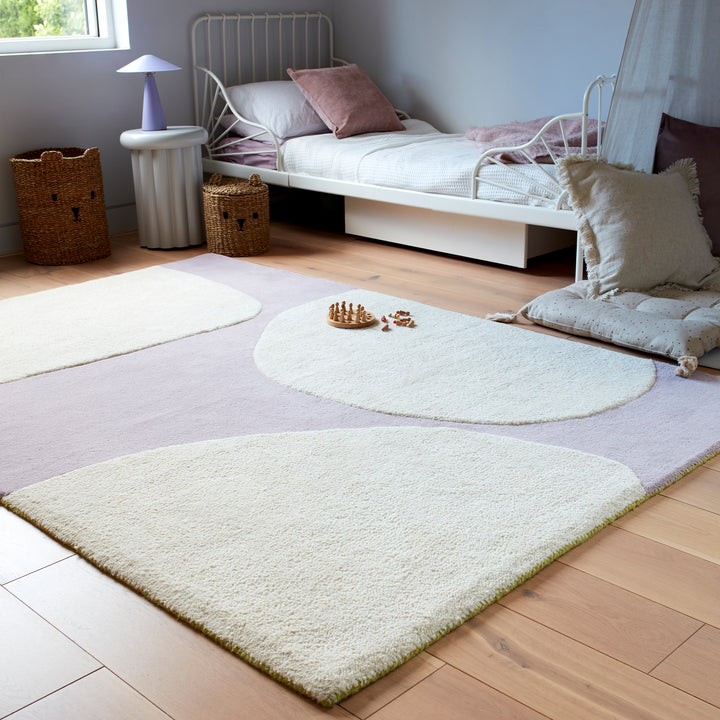くすんだパープルカラーといびつな大きめフォルムがかわいい、天然素材のウール100％RUGHAUSのハンドタフトアートラグを主役にしたガーリーなベッドルームイメージ