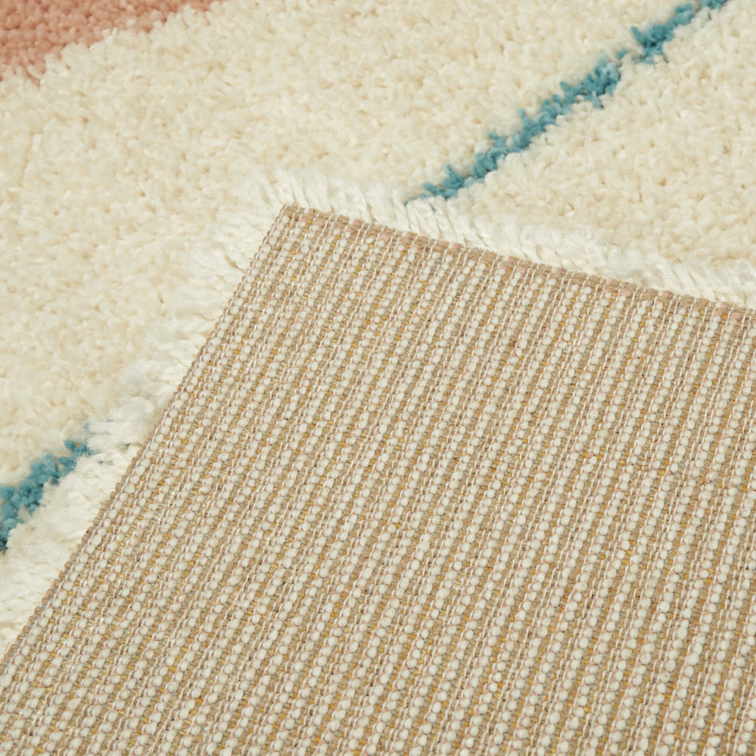ふわふわとした手触りと厚み、マスタード×ダスティピンクのポップな幾何学パターンが魅力的なコンテンポラリーモダンラグの素材感と裏地がわかるクロースアップ