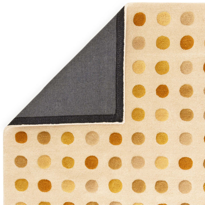 イエローベージュとプルカドット（Pulka Dot）の水玉デザインがキュートな、天然素材ウール100％RUGHAUSの手織りハンドタフトのアートラグの素材感と裏面がわかるクロースアップ