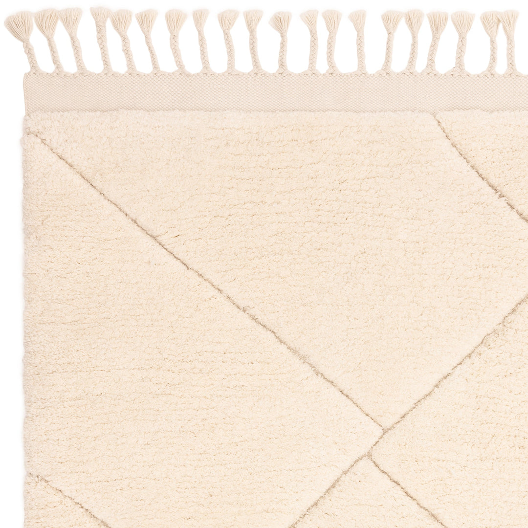 伝統的なベルベルキリムのテクスチャーやデザインにインスパイアされて織り上げた、ふわふわとした柔らかなマイクロファイバーポリエステル製RUGHAUSのベージュ・アイボリー色のベニワレンスタイルモロッカンラグの素材感がわかるクロースアップ