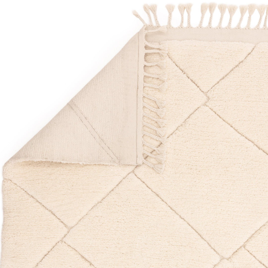 伝統的なベルベルキリムのテクスチャーやデザインにインスパイアされて織り上げた、ふわふわとした柔らかなマイクロファイバーポリエステル製RUGHAUSのベージュ・アイボリー色のベニワレンスタイルモロッカンラグの素材感と裏面がわかるクロースアップ