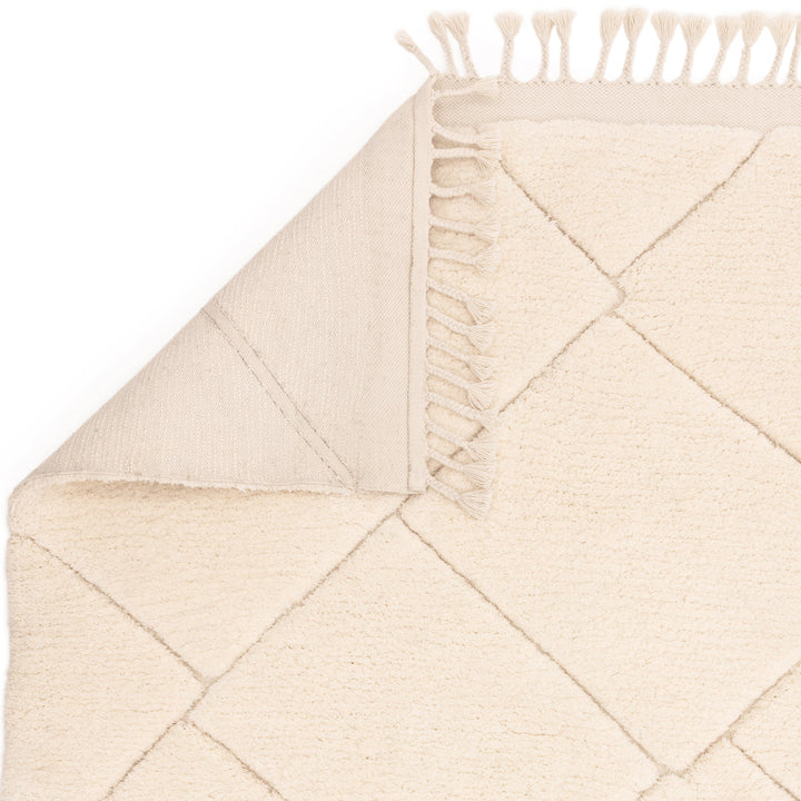伝統的なベルベルキリムのテクスチャーやデザインにインスパイアされて織り上げた、ふわふわとした柔らかなマイクロファイバーポリエステル製RUGHAUSのベージュ・アイボリー色のベニワレンスタイルモロッカンラグの素材感と裏面がわかるクロースアップ