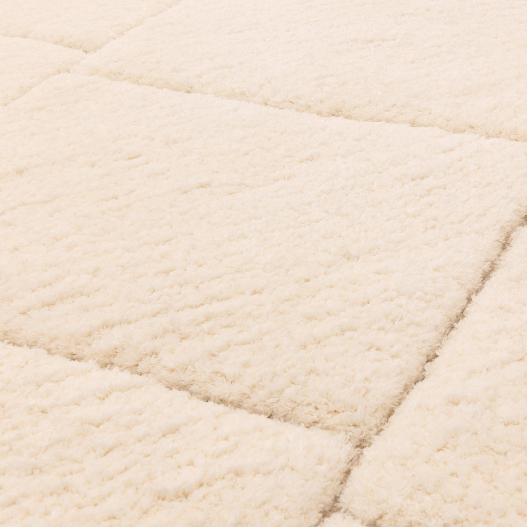 伝統的なベルベルキリムのテクスチャーやデザインにインスパイアされて織り上げた、ふわふわとした柔らかなマイクロファイバーポリエステル製RUGHAUSのベージュ・アイボリー色のベニワレンスタイルモロッカンラグの素材感がわかるクロースアップ