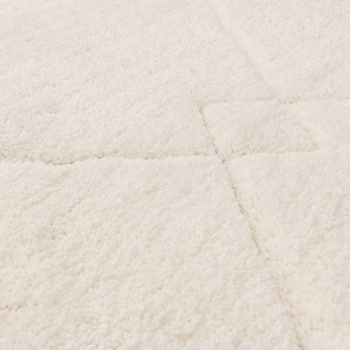 伝統的なベルベルキリムのテクスチャーやデザインにインスパイアされて織り上げた、ふわふわとした柔らかなマイクロファイバーポリエステル製RUGHAUSのベージュ・アイボリー色のベニワレンスタイルモロッカンラグの素材感がわかるクロースアップ