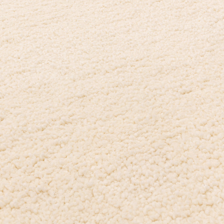 伝統的なベルベルキリムのテクスチャーやデザインにインスパイアされて織り上げた、ふわふわとした柔らかなマイクロファイバーポリエステル製RUGHAUSのベージュ・アイボリー色のシンプルなモロッカンラグの素材感がわかるクロースアップ