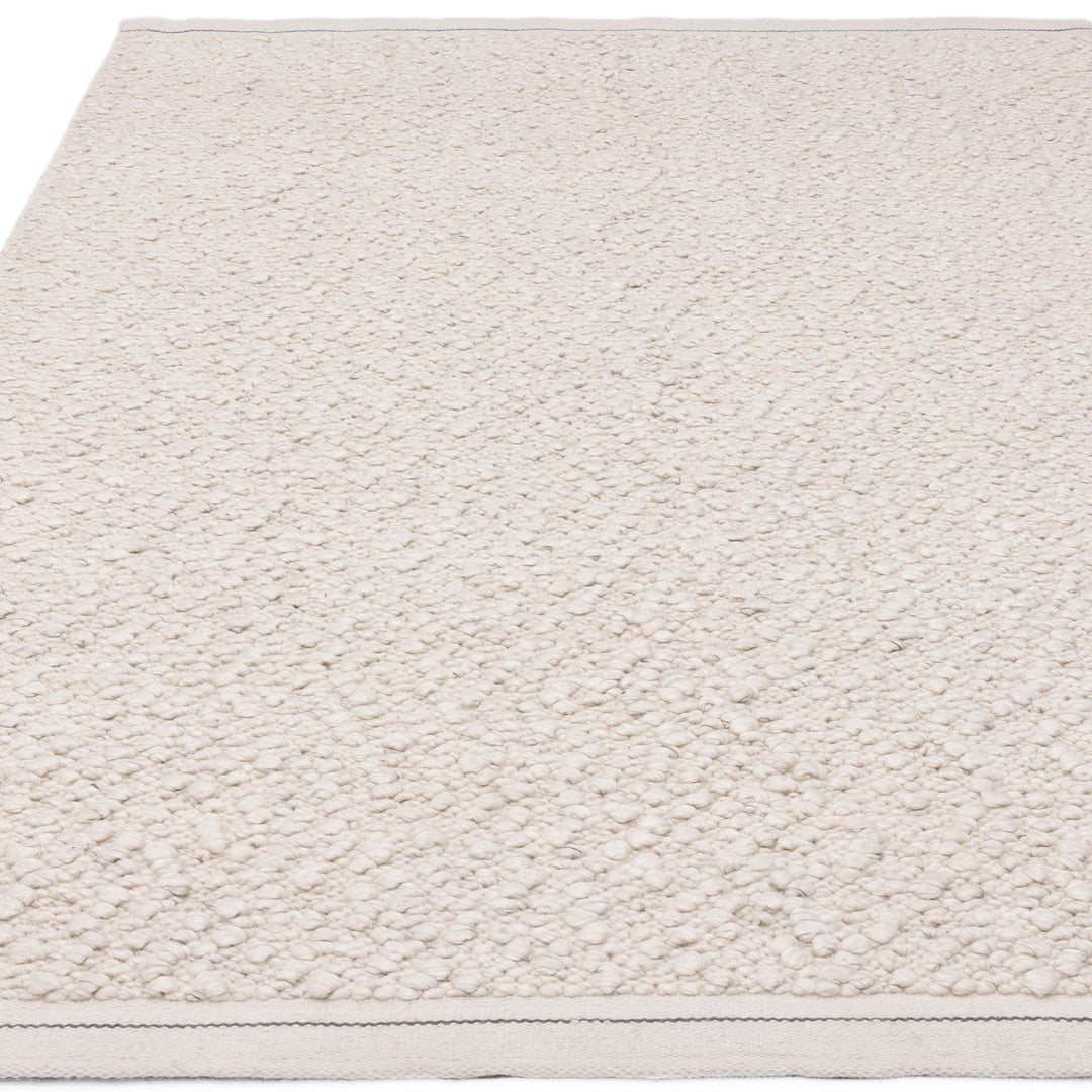 200x300cm大きめサイズのアイボリーの優しい色合いと、ブークレ（Boucle）織りのざっくりとした風合いがパーフェクトにマッチした、RUGHAUSの手織りのシンプルモダンラグ