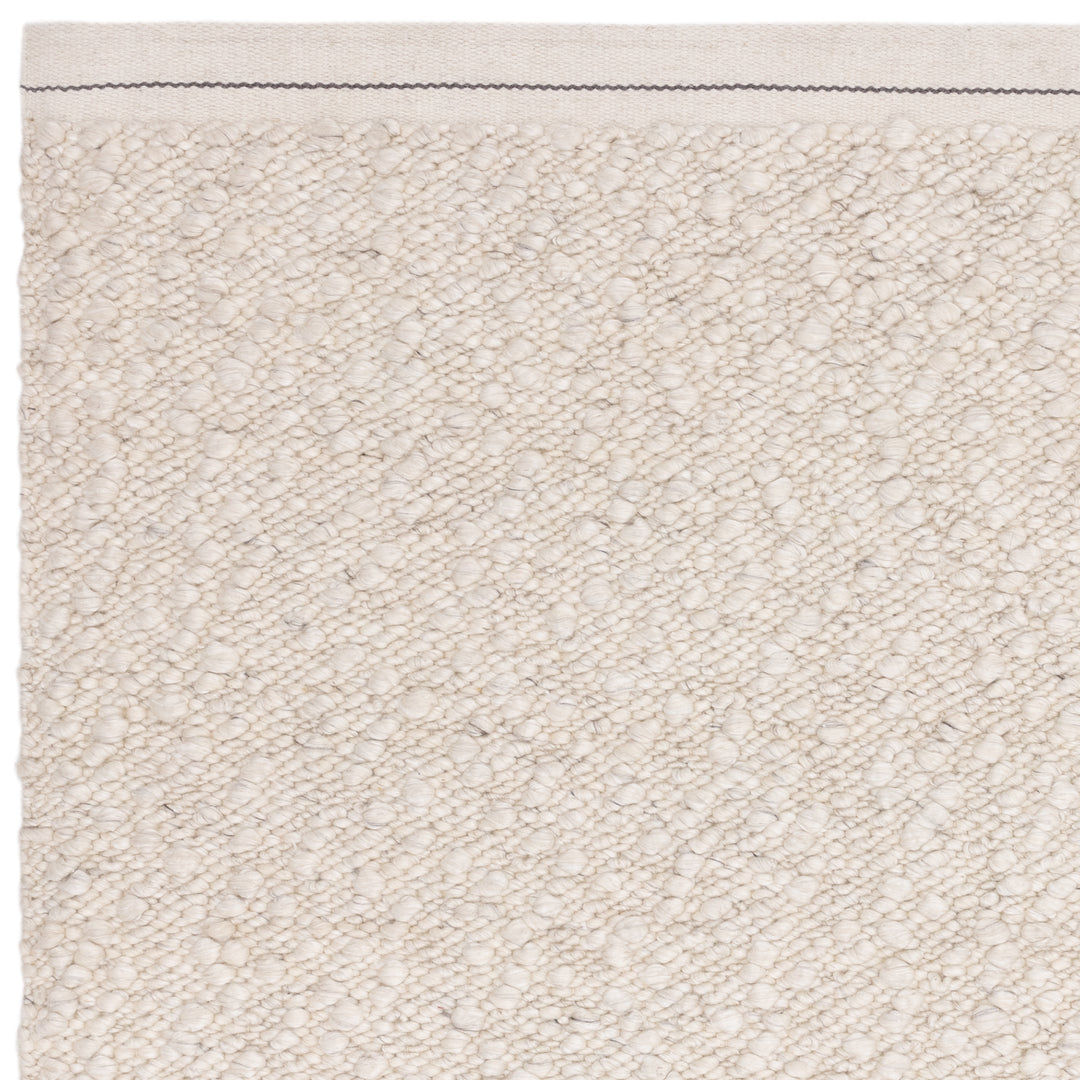 アイボリーの優しい色合いと、ブークレ（Boucle）織りのざっくりとした風合いがパーフェクトにマッチした、RUGHAUSの手織りのシンプルモダンラグの素材感がわかるクロースアップ