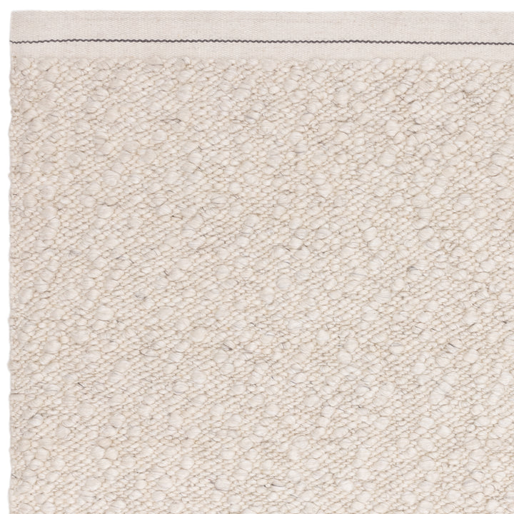 アイボリーの優しい色合いと、ブークレ（Boucle）織りのざっくりとした風合いがパーフェクトにマッチした、RUGHAUSの手織りのシンプルモダンラグの素材感がわかるクロースアップ