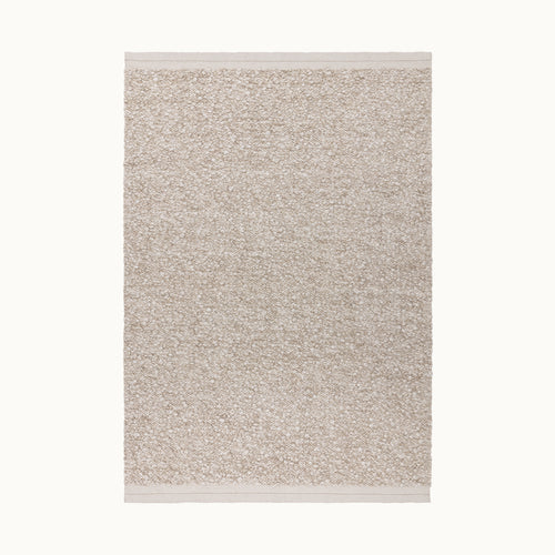 160x230cmサイズの羊毛そのままのようなベージュの暖かな色合いと、ブークレ（Boucle）織りのざっくりとした風合いがパーフェクトにマッチした、RUGHAUSの手織りのシンプルモダンラグ